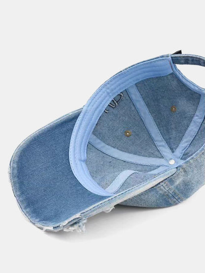 Boné jeans desgastado, com aba desfiada e slogan “Nunca desista” bordado