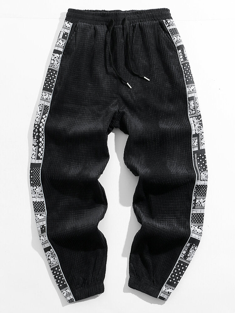 Calça de veludo cotelê com painéis estampados de paisley